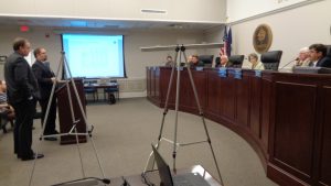 “Do NOT go to the light,” Davenport & Associates' Ted Cole, left, and Sand Anderson at-torney Jesse Bausch may have been explaining of their Power Point (on far wall) on the quickly-changing financial dynamics at play in a potential bond reissue on a portion of the County’s 2011 bond reissue of $45.7-million. The bottom line is the savings “in the light” on the wall had lost almost a quarter of $667,000 in projected savings in 2 weeks, with nearly 3 more weeks of potential additional losses before interest rates on a VRS Bond issue will be set.