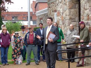 On May 4, Daniel Pond III explained the Real Estate Auction process as interested buy-ers, then-Assistant County Attorney Dan Whitten (background, cool black hat and shades), among others, listen.
